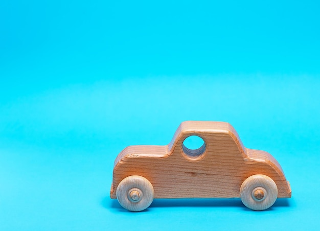 Close-up of wooden toy car against blue background