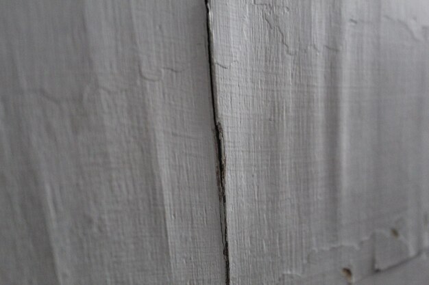 A close up of a wooden wall with a crack in it
