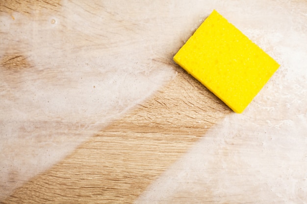 Close up of worker hand wiping dust in office in yellow gloves