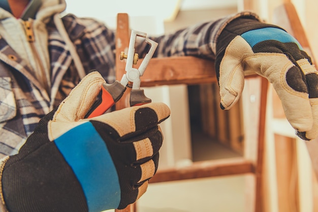 Photo close up of worker holding electrical tool