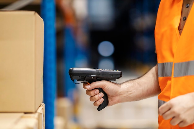 Photo close up of worker loading bar code with reader in storage