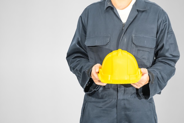 Photo close up worker standing in blue coverall holding hardhat