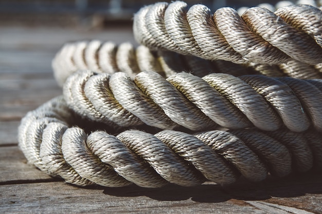 Close up of worn out thick mooring rope on wooden pier. Can use as banner.