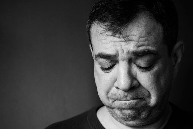 Photo close-up of worried man against gray background