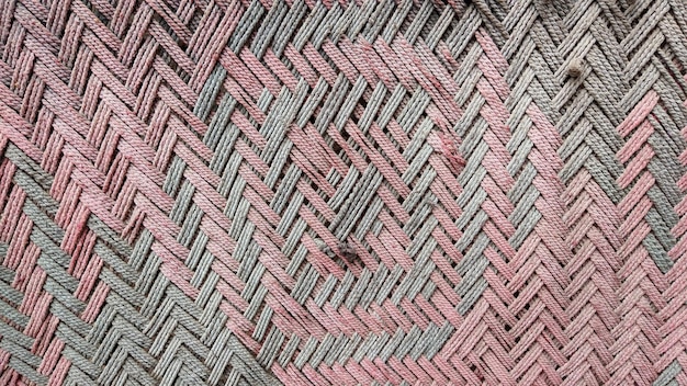 A close up of a woven pattern with pink and gray stripes.
