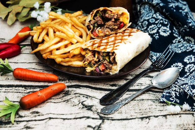 Photo close-up of wrap sandwich with french fries on table
