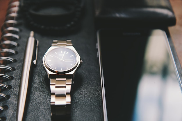 Photo close-up of wristwatch and smart phone on book