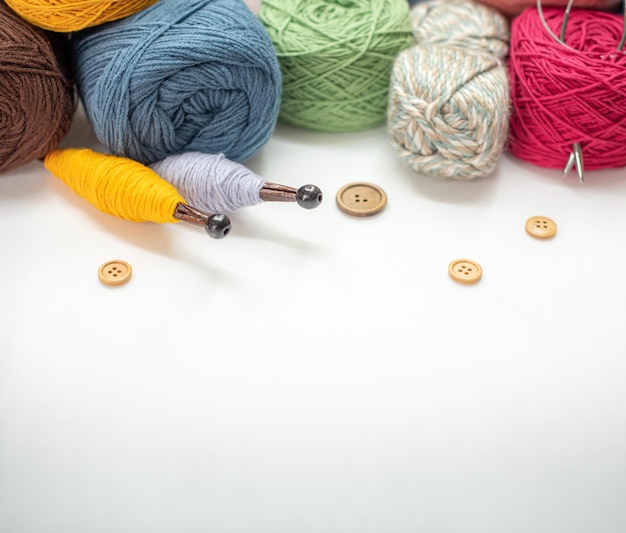 Close up of yarn balls rainbow colors yarn for knitting skeins\
of yarn knitting needles