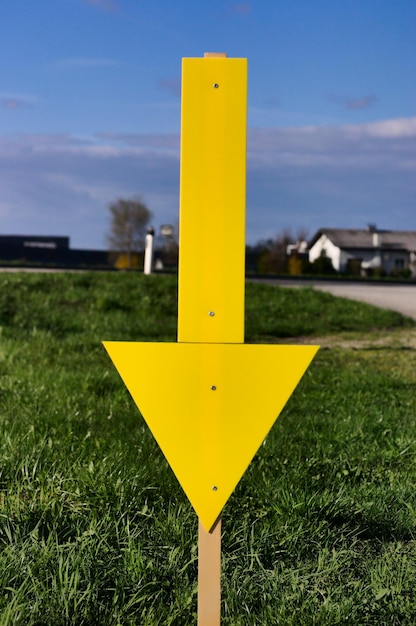 Photo close-up of yellow arrow symbol on grassy field