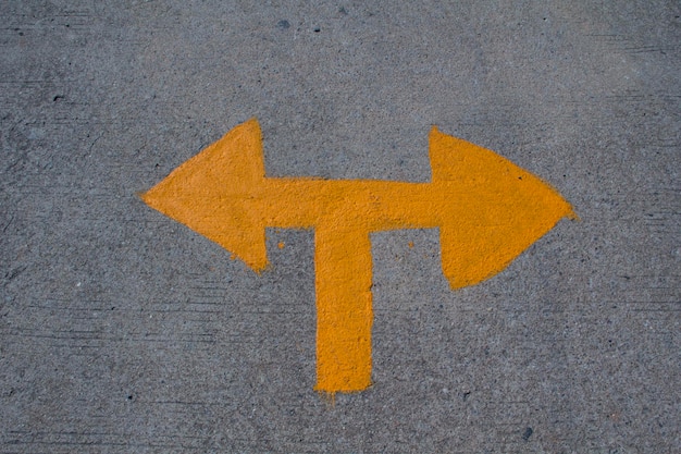 Photo close-up of yellow arrow symbol on road