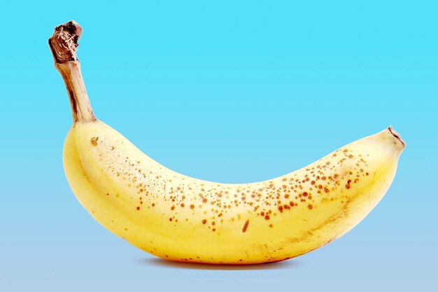 Foto close-up di una banana gialla su sfondo blu