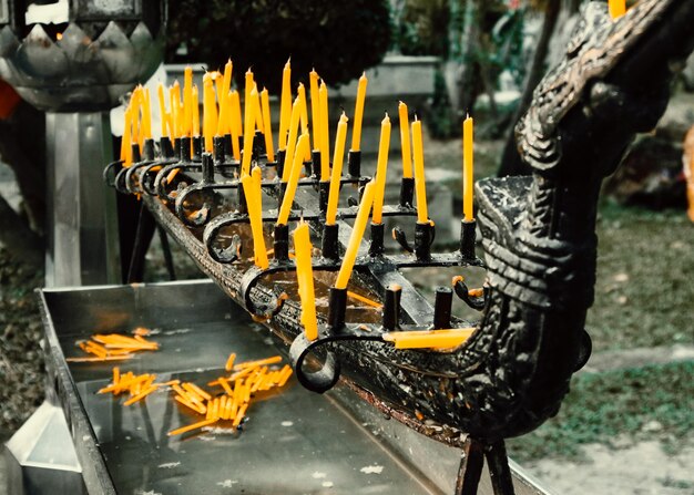 Close-up of yellow candles in temple