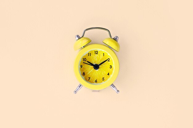 Close-up of yellow clock over white background