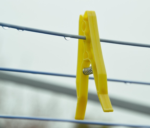 Foto close-up di una pinza gialla sul filo del bucato