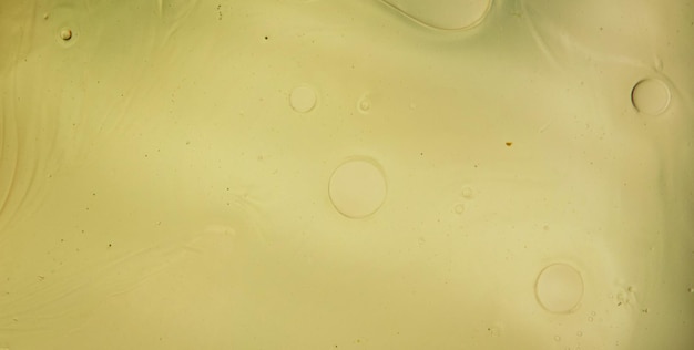 close-up of yellow liquid with floating bubbles and a gradient effect