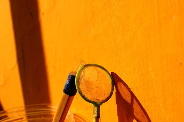 Close-up of yellow pipe against orange wall