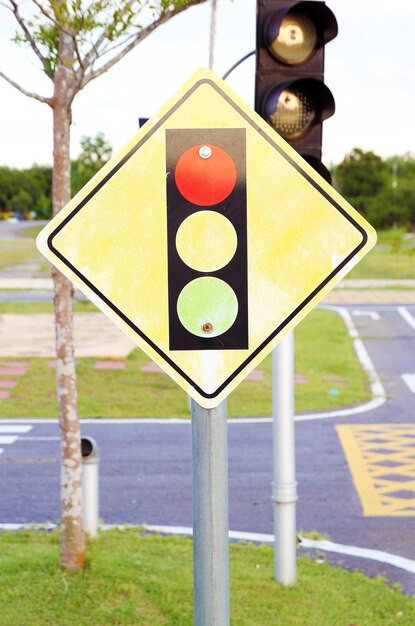 Photo close-up of yellow road sign on street