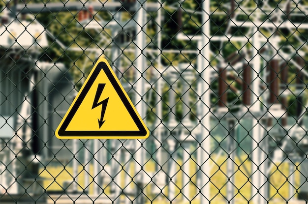 Close-up of yellow sign on chainlink fence