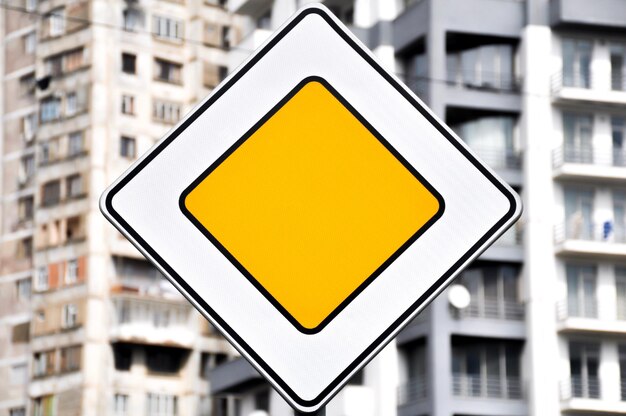 Photo close-up of yellow sign on metal in city