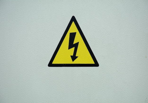 Photo close-up of yellow sign on wall