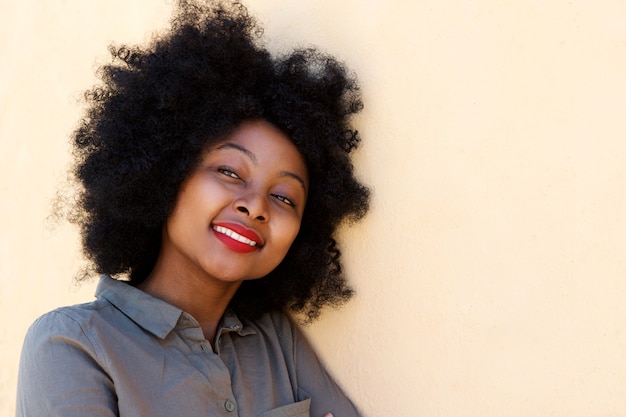 Close up young african woman smiling and thinking