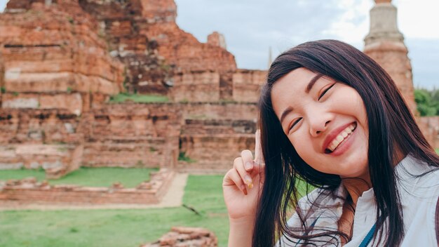 Close-up Young Asian backpacker blogger woman at pagoda old city