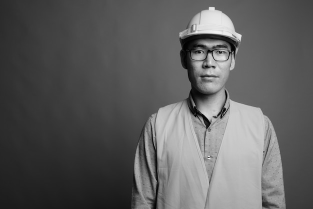Крупным планом молодой азиатский человек строитель в очках
