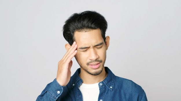 close up of young asian man doubting while standing over isolated grey background