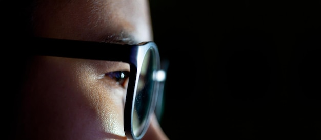 Close up of Young Asian man in glasses watching videos and surfing internet on technology device