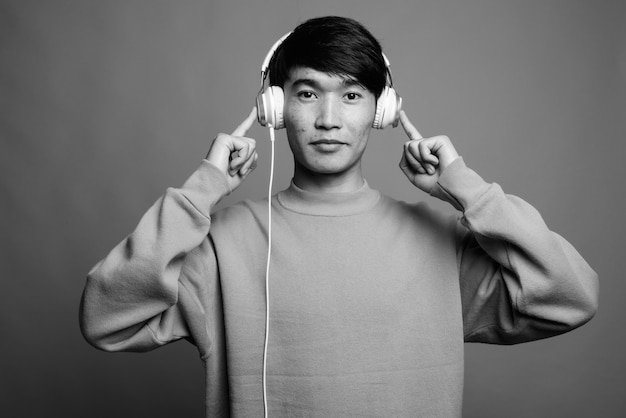 Close up of young Asian man listening to music