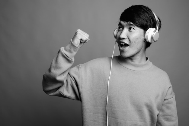 Close up of young Asian man listening to music