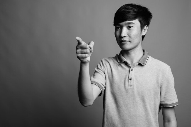 Close up of young Asian man wearing gray polo shirt