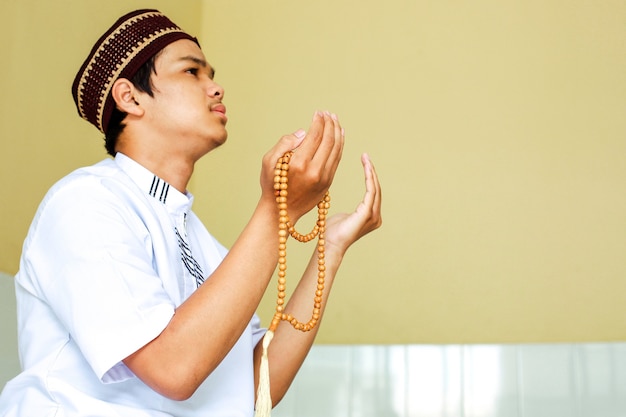 Close up of young asian muslim praying to God