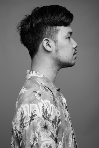 Close up of young Asian tourist man wearing Hawaiian shirt ready for vacation