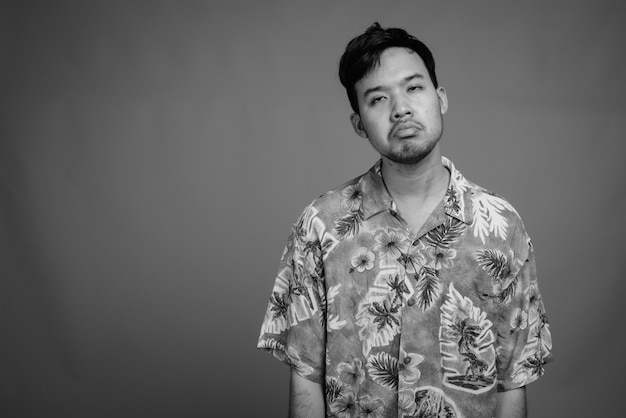 Close up of young Asian tourist man wearing Hawaiian shirt ready for vacation