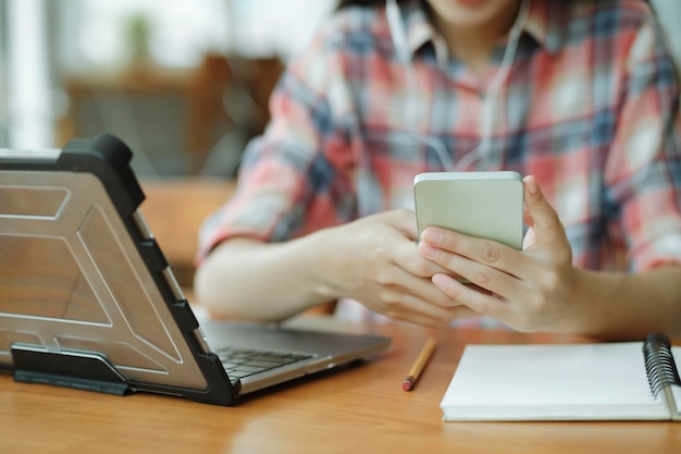 Chiuda sulla giovane donna asiatica facendo uso del telefono cellulare