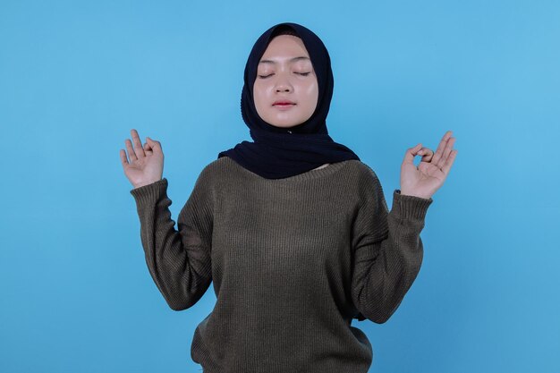 Close up on young attractive and charismatic woman on blue wall