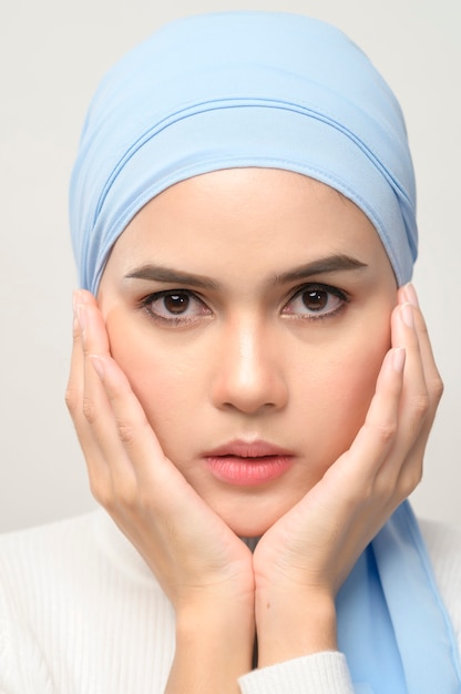 A close up of young beautiful muslim woman with hijab isolated on white background studio, muslim beauty skin care concept.