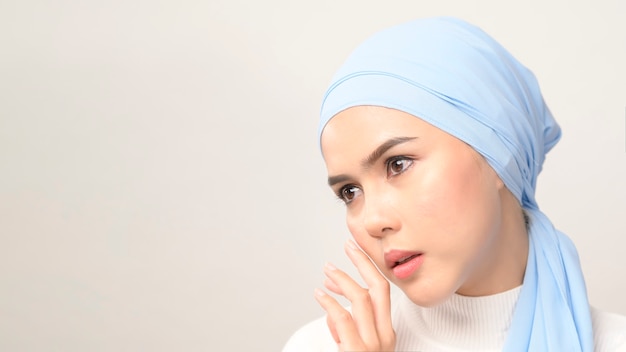 A close up of young beautiful muslim woman with hijab isolated on white, muslim beauty skin care concept.