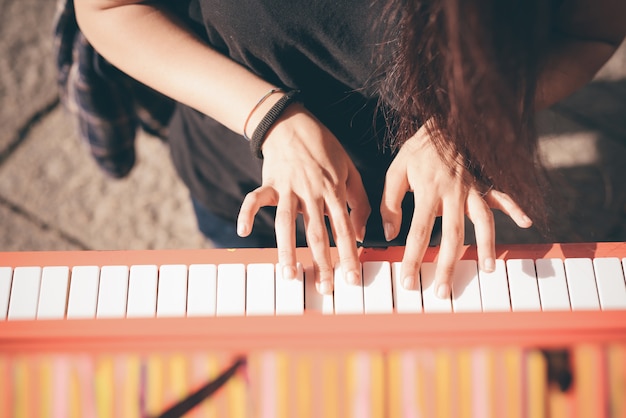 Close up of a young beautiful redhead caucasian girl playing piano