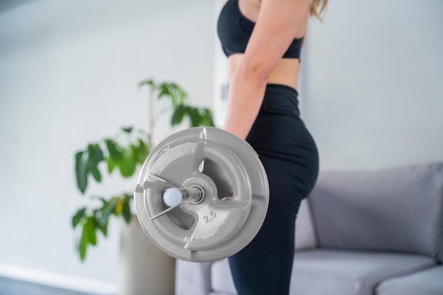 Close up Young and beautiful woman doing exercise with bar at home