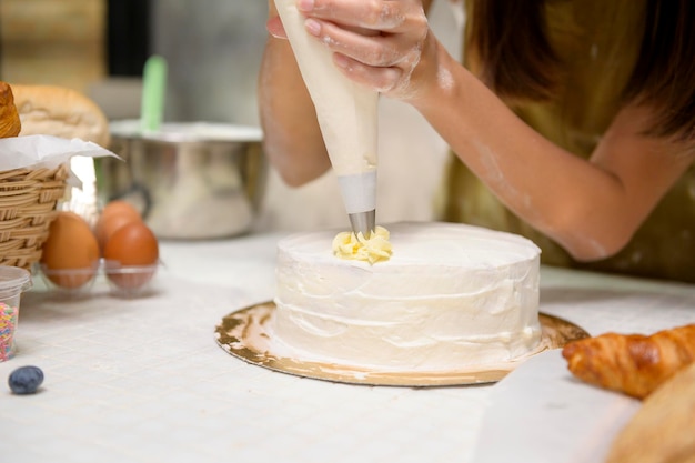 Primo piano di giovane bella donna sta cuocendo nella sua cucina panetteria e caffetteria