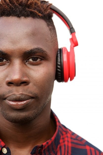 Close up young black guy listening to music with headphones