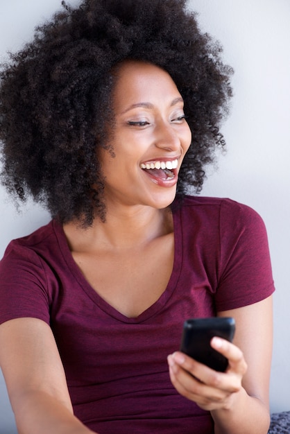 Close up young black woman laughing with mobile phone