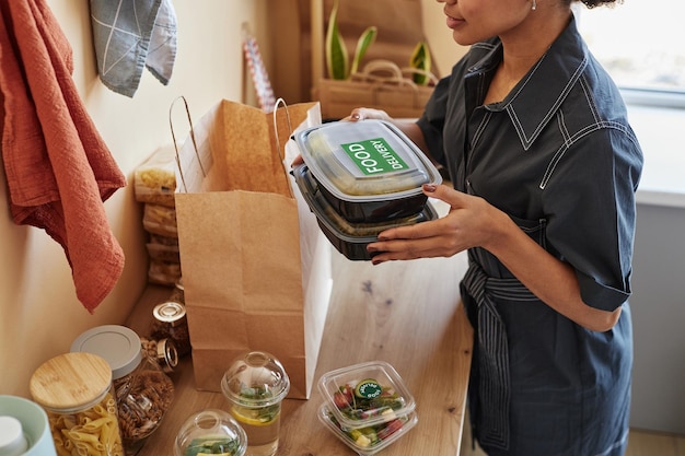 Photo close up of young black woman unpacking food delivery order