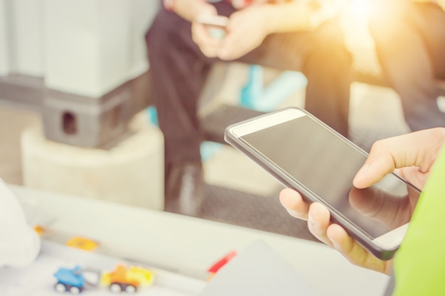 Close up of young business engineer man using mobile smartphone