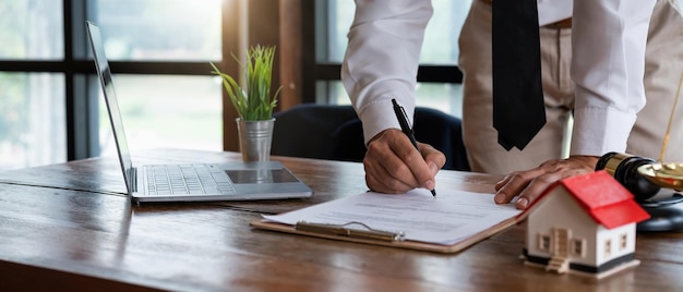 Close up young businessman standing near table with pen in hands ready signing profitable offer agreement after checking contract terms of conditions executive manager involved in legal paperworkxA