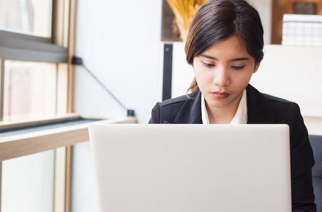 ラップトップを使用している若いビジネスウーマンをクローズアップ