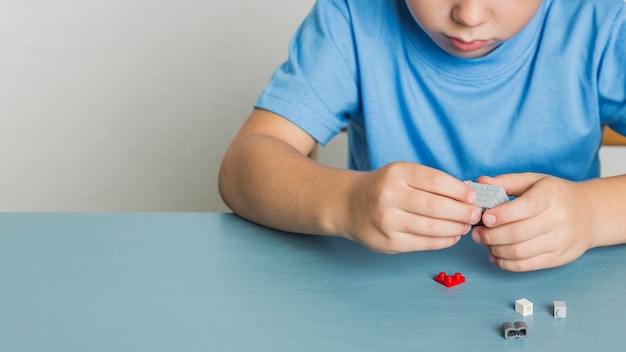 Foto bambino piccolo del primo piano che gioca con il lego