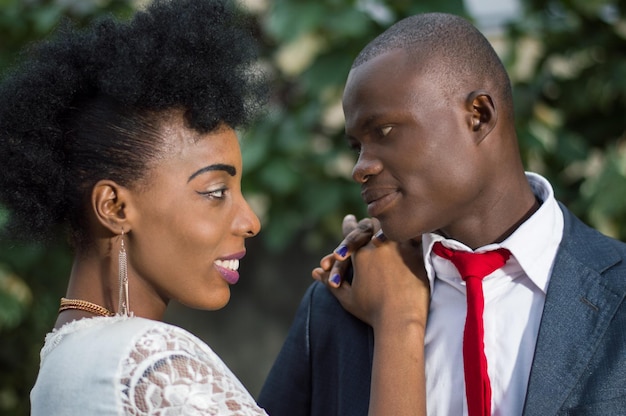 Close-up of young couple in love face to face outside and looking at each other in the eyes smiling